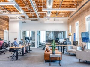 Modernt coworking-kontor med öppen planlösning och ergonomiska arbetsplatser.