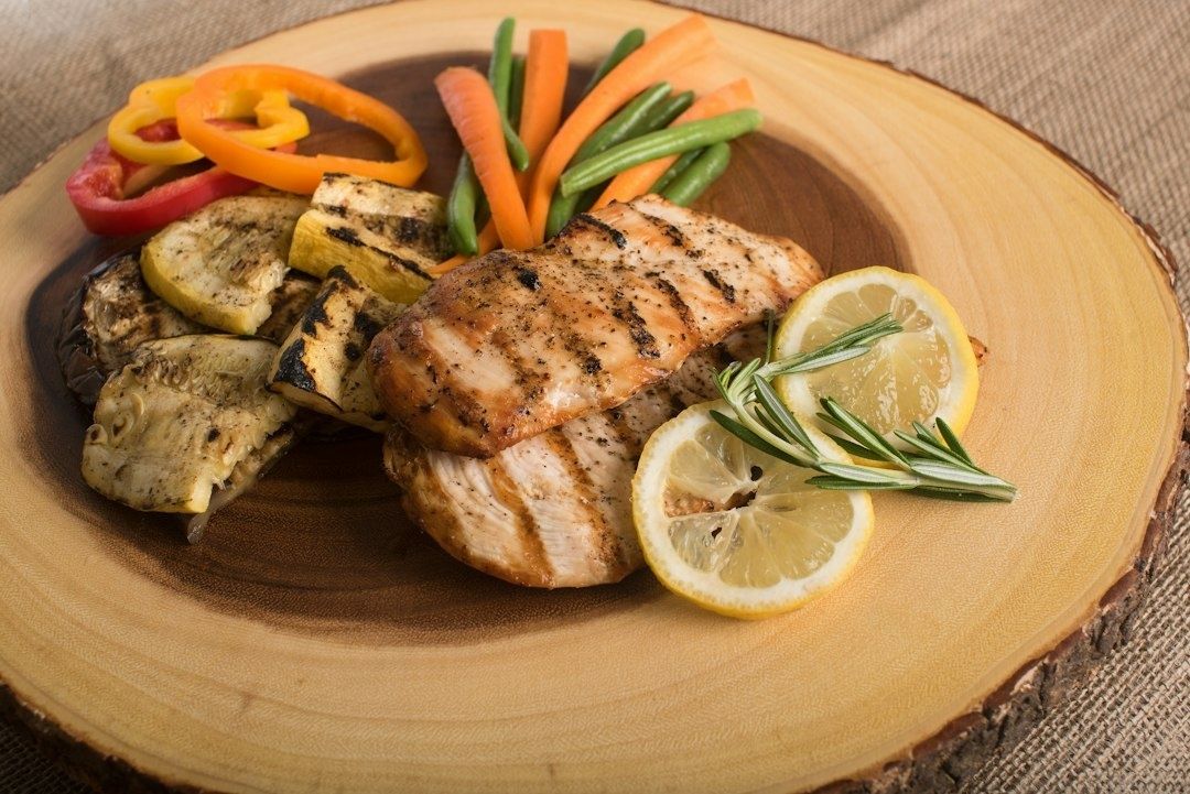 Grillad kyckling med grönsaker, citron och rosmarin på träfat